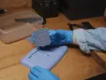 Mani guantate che estraggono un motivo floreale da stampi fai da te in silicone.