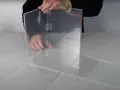 Costruzione di una teca in plexiglass fai da te, con pannelli trasparenti assemblati con nastro adesivo.