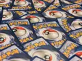 Un mucchio di carte Pokémon, con il logo giallo e il design della Poké Ball. Queste sono tra le carte Pokémon più belle per ogni collezionista.