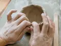 Mani esperte modellano argilla, creando una ciotola. Immagina di colorare il das con lo smalto per un tocco artistico.