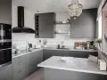 Cucina moderna con mobili color titanio, cappa nera, piano in quarzo bianco e lampadario di cristallo.