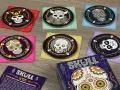 Dischi colorati con teschi decorati, pronti per una partita al gioco Skull.