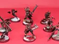 Un gruppo di guerrieri minacciosi, pronti per i giochi miniature. Le loro armature sono dettagliate e le armi affilate, con basi innevate e macchiate di sangue.