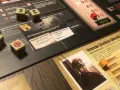 Dadi con simboli di mira e numeri, un ritratto di un generale tedesco e carte di gioco. Un'ambientazione da tavolo che evoca un black orchestra.