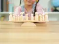 Bambini giocano con pedine di legno su una bilancia, un'idea per i migliori giochi da tavolo cooperativi.