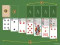 Un tavolo da gioco verde con carte da giochi di carte da tavolo solitario disposte. Ci sono quattro assi in alto e sette colonne di carte sotto.