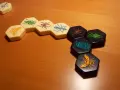 Pezzi esagonali del **hive gioco da tavolo** con insetti colorati disposti su un tavolo di legno.