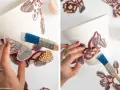 Applicazione di decorazioni floreali su un vaso bianco, usando un pennello per stendere un prodotto simile a mod podge.