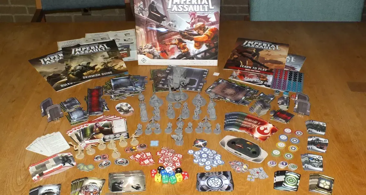 Tavolo pieno di componenti per il gioco da tavolo Star Wars: Imperial Assault. Miniature, carte, dadi e manuali pronti per un assalto imperiale.