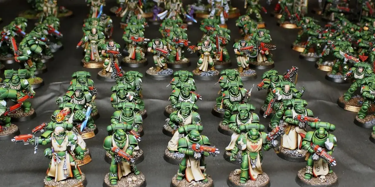Un esercito di guerrieri in armatura verde, i dark angels, pronti alla battaglia con armi scintillanti.