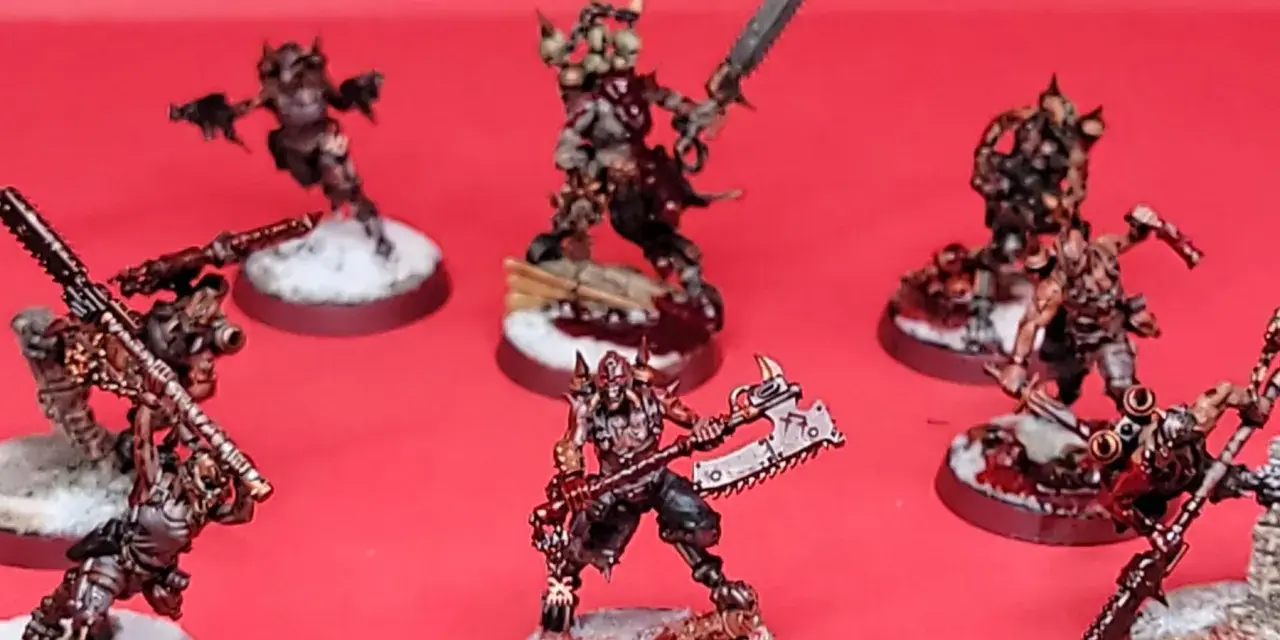 Un gruppo di guerrieri minacciosi, pronti per i giochi miniature. Le loro armature sono dettagliate e le armi affilate, con basi innevate e macchiate di sangue.