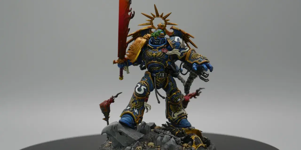 Roboute Guilliman, Primarca degli Ultramarines, brandisce la spada ardente su un campo di battaglia disseminato di teschi.
