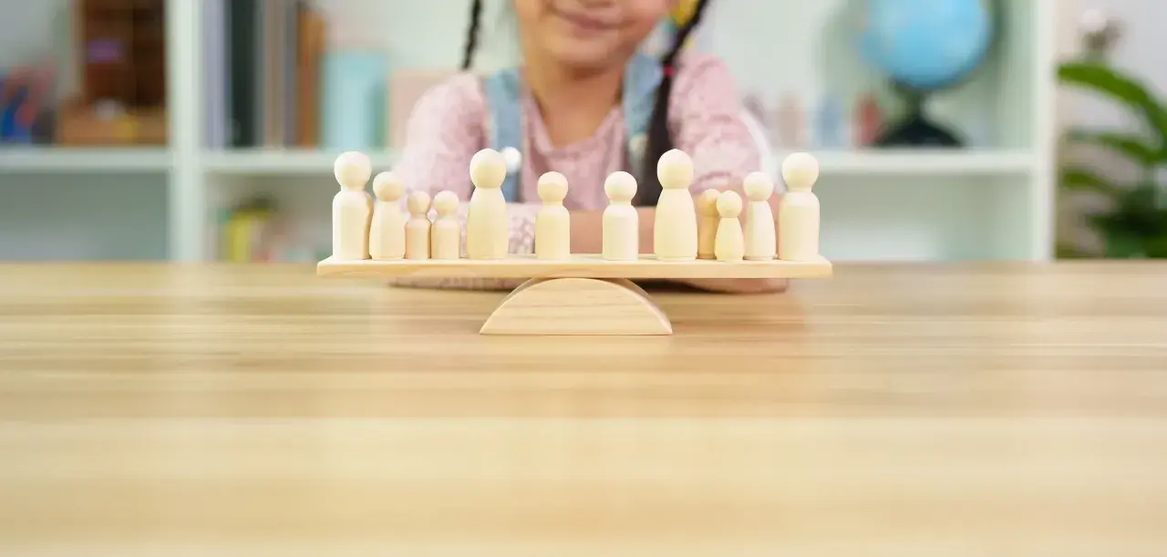 Bambini giocano con pedine di legno su una bilancia, un'idea per i migliori giochi da tavolo cooperativi.