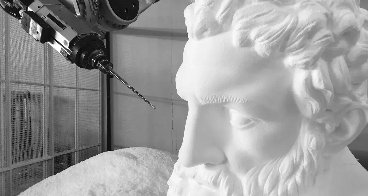 Un braccio robotico con una punta da trapano si avvicina a un busto di polistirolo, suggerendo un metodo innovativo per come sciogliere il polistirolo.