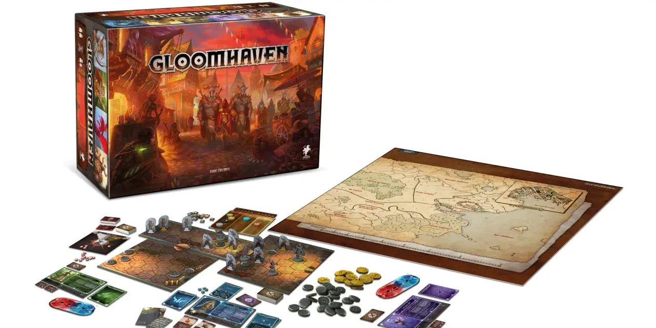 La scatola di Gloomhaven, la mappa del mondo e i componenti del gioco pronti per una nuova avventura. Una recensione di questo epico gioco da tavolo.