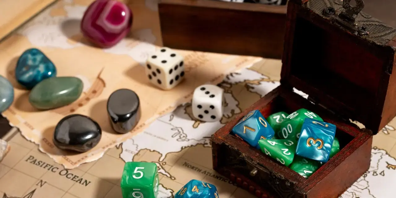 Dadi colorati e pietre preziose su una mappa antica, pronti per i migliori giochi da tavolo.