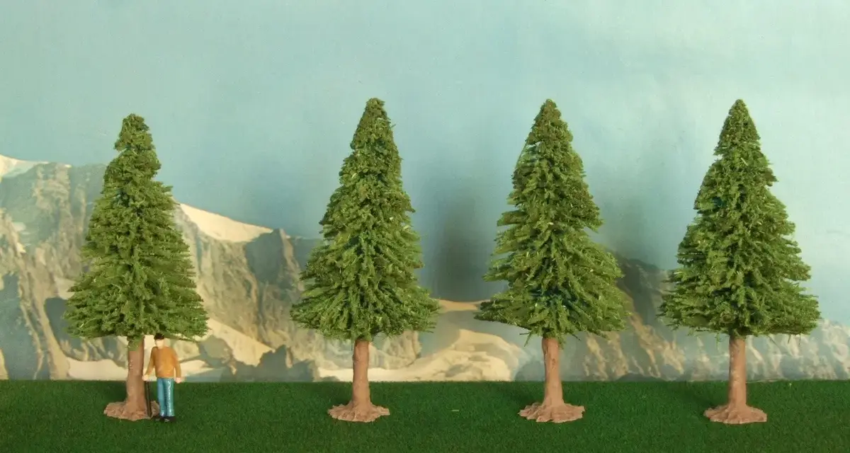 Un piccolo uomo osserva la scena, mentre si prova a costruire un albero finto. Quattro alberi verdi su un prato artificiale, con montagne sullo sfondo.