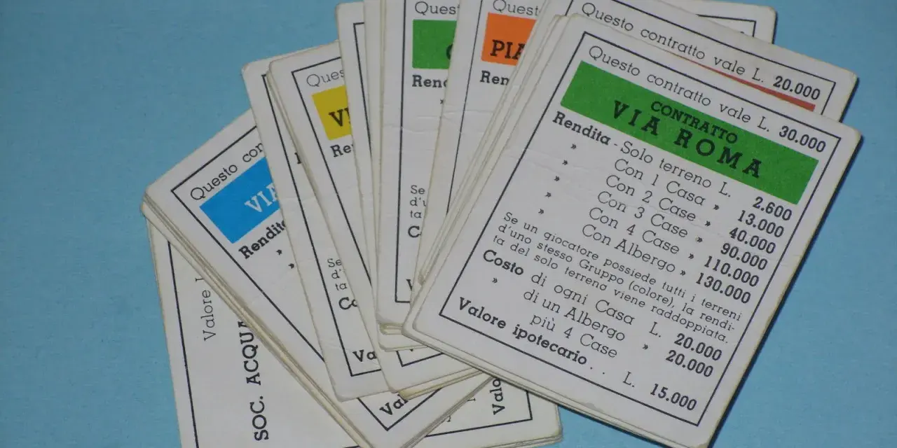 Carte di proprietà del Monopoli, con dettagli sulle rendite e i costi per costruire case e alberghi, fondamentali per le regole del gioco.