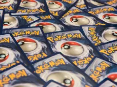 Un mucchio di carte Pokémon, con il logo giallo e il design della Poké Ball. Queste sono tra le carte Pokémon più belle per ogni collezionista.