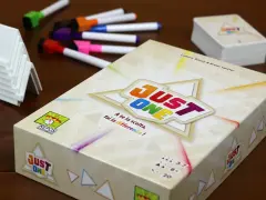 Scatola del gioco da tavolo "Just One" con pennarelli colorati e supporti bianchi. Un gioco per tutti!