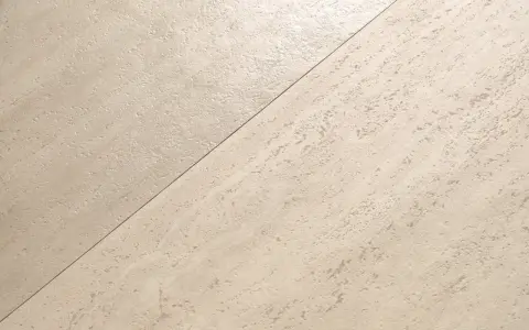Superficie chiara divisa diagonalmente: a sinistra, finitura opaca; a destra, finitura satinata. La differenza tra opaco e satinato è evidente.