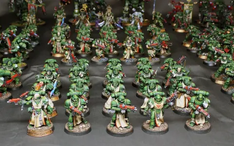 Un esercito di guerrieri in armatura verde, i dark angels, pronti alla battaglia con armi scintillanti.