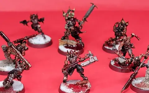 Un gruppo di guerrieri minacciosi, pronti per i giochi miniature. Le loro armature sono dettagliate e le armi affilate, con basi innevate e macchiate di sangue.