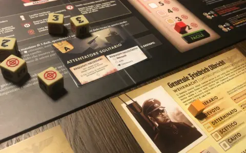 Dadi con simboli di mira e numeri, un ritratto di un generale tedesco e carte di gioco. Un'ambientazione da tavolo che evoca un black orchestra.
