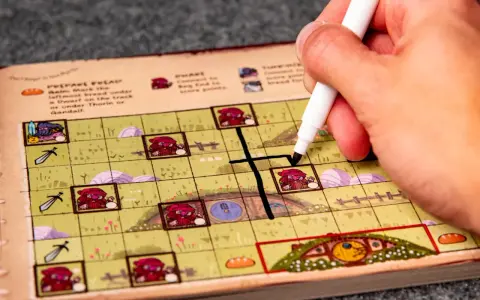 Mano che segna una casella su una plancia colorata, parte del gioco da tavolo "Hobbit il gioco".