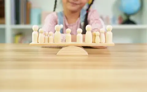 Bambini giocano con pedine di legno su una bilancia, un'idea per i migliori giochi da tavolo cooperativi.