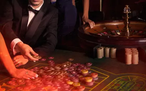 Mani che giocano a las vegas gioco carte, con fiches e roulette in un'atmosfera da casinò.