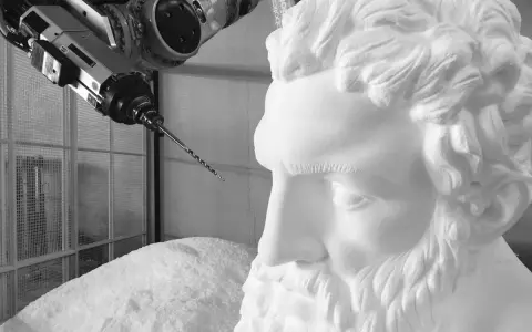Un braccio robotico con una punta da trapano si avvicina a un busto di polistirolo, suggerendo un metodo innovativo per come sciogliere il polistirolo.