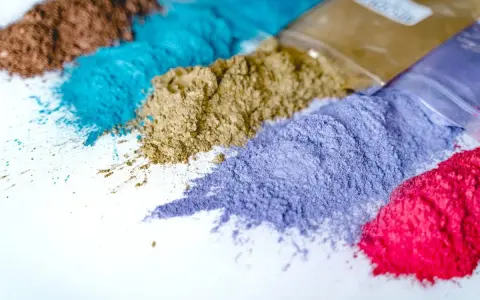 Variopinti pigmenti in polvere, pronti per essere usati in creazioni artistiche.