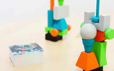 Costruzioni colorate in stile junk art, con una pila di carte in primo piano.