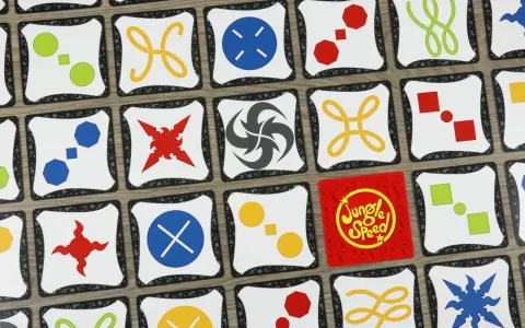 Carte di Jungle Speed con simboli colorati. Le regole del gioco sono semplici: trova le coppie di simboli identici per vincere.