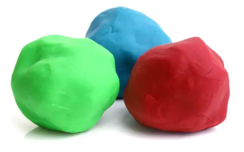 Tre masse di materiale plastico modellabile: verde, blu e rosso, pronte per creare forme fantastiche.
