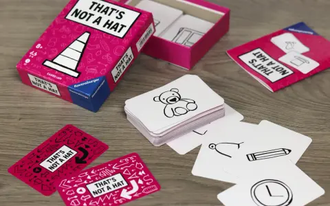 Scatola e carte del gioco "That's Not a Hat" con disegni di orsacchiotti, matite e orologi.