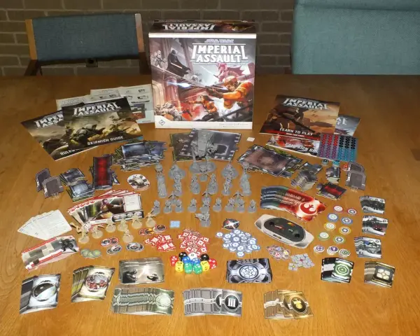 Tavolo pieno di componenti per il gioco da tavolo Star Wars: Imperial Assault. Miniature, carte, dadi e manuali pronti per un assalto imperiale.