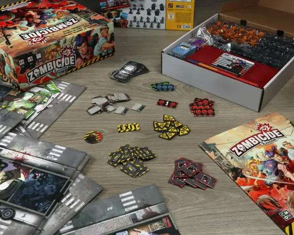La scatola di Zombicide 2ª Edizione, plance modulari, miniature e segnalini pronti per una recensione avvincente.