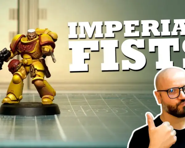 Miniatura di un guerriero degli Imperial Fists, giallo e rosso, con fucile. Un uomo con occhiali fa pollice in su.