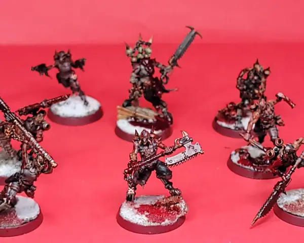 Un gruppo di guerrieri minacciosi, pronti per i giochi miniature. Le loro armature sono dettagliate e le armi affilate, con basi innevate e macchiate di sangue.