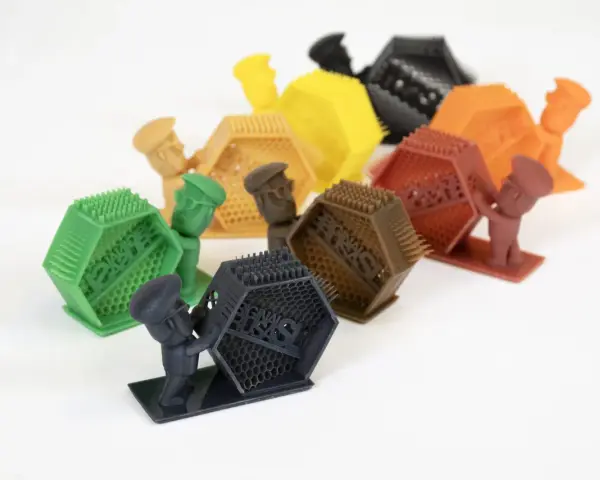 Piccoli omini colorati sorreggono oggetti esagonali con punte. Attenzione, respirare resina fa male!