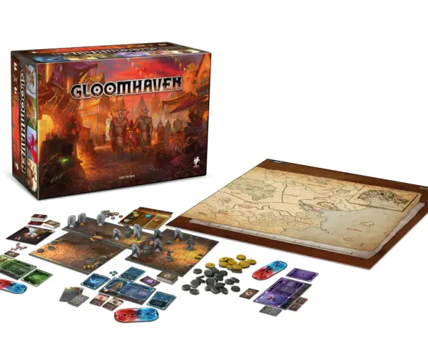 La scatola di Gloomhaven, la mappa del mondo e i componenti del gioco pronti per una nuova avventura. Una recensione di questo epico gioco da tavolo.