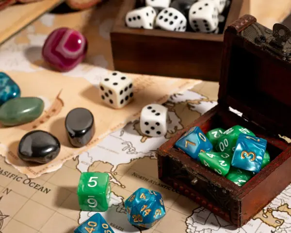 Dadi colorati e pietre preziose su una mappa antica, pronti per i migliori giochi da tavolo.