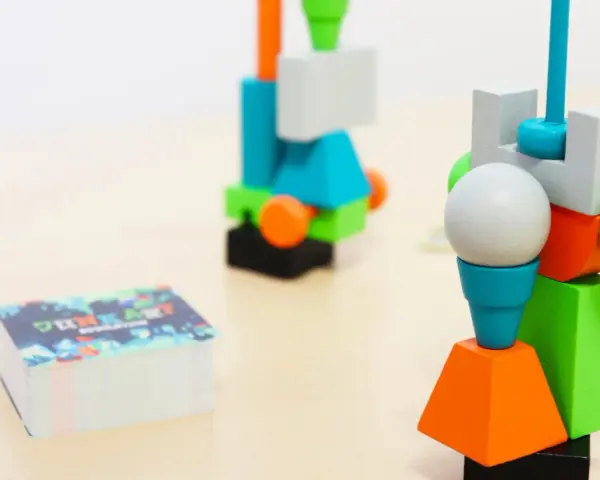 Costruzioni colorate in stile junk art, con una pila di carte in primo piano.