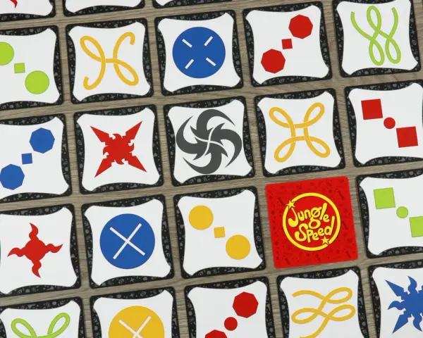 Carte di Jungle Speed con simboli colorati. Le regole del gioco sono semplici: trova le coppie di simboli identici per vincere.