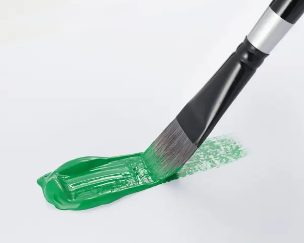 Pennello stende un brillante verde acrilico su carta bianca, creando un'opera d'arte fai da te.