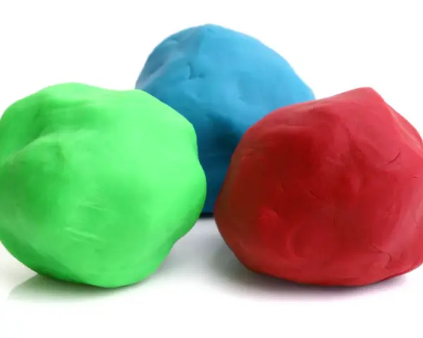 Tre masse di materiale plastico modellabile: verde, blu e rosso, pronte per creare forme fantastiche.