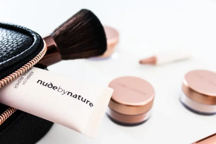 Tubo di primer minerale Airbrush Nude by Nature e pennello da trucco, con barattoli in primo piano. Ottima alternativa per chi cerca cosa usare al posto del primer.