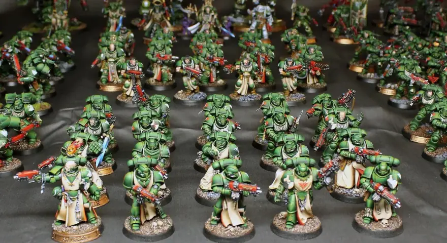 Un esercito di guerrieri in armatura verde, i dark angels, pronti alla battaglia con armi scintillanti.